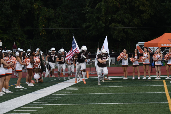 Seniors Josh Wright and Brendan Singleton lead the Pascack Hills Football Team out onto the field for their home opener.